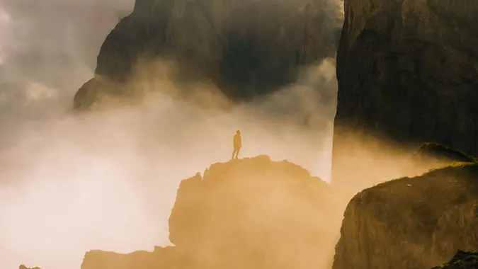 A man standing on the Seceda rock formation, South Tyrol, Italy