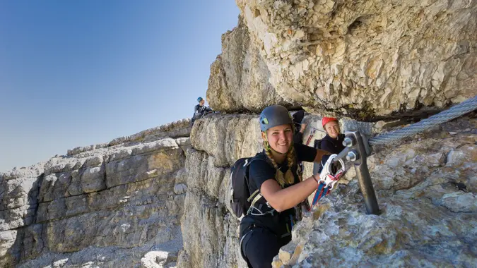 Woman conquering a via ferrata in the breathtaking Dolomites landscape