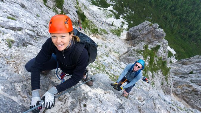 Climbers conquering the rock faces of the Dolomite mountains in Italy