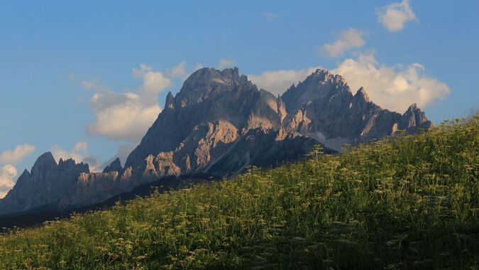 The imposing peaks of the Dolomites stand out against the morning sky