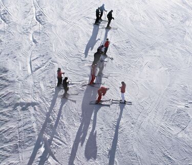 Skiers on white slope